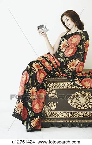 Young woman looking at a mobile phone View Large Photo Image Picture - Young woman looking at a mobile phone. Fotosearch