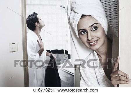 Stock Image - Young woman looking away with a young man standing behind her. Fotosearch