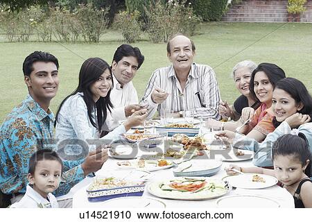 Portrait of a family sitting at a table View Large Photo Image Stock Image - Portrait of a family sitting at a table. Fotosearch