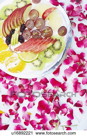 Stock Image - Close-up of a dish of salad with flower petals around it. Fotosearch