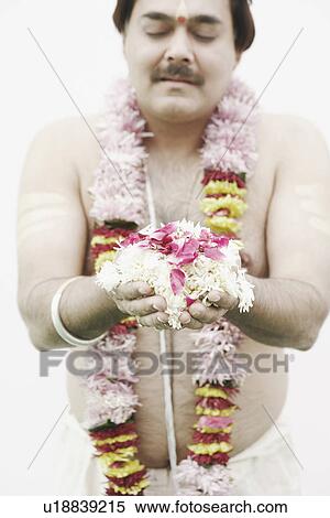Close-up of a priest holding flowers View Large Photo Image Stock Photography - Close-up of a priest holding flowers. Fotosearch