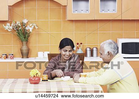 Mature couple having tea at the dining table View Large Photo Image Picture - Mature couple having tea at the dining table. Fotosearch