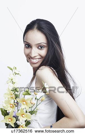 Stock Photograph - Portrait of a teenage girl holding a bunch of flowers. Fotosearch