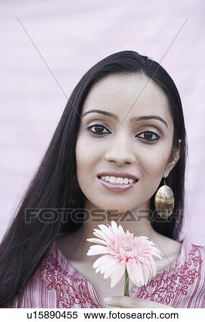 Stock Photography - Portrait of a teenage girl holding a flower. Fotosearch