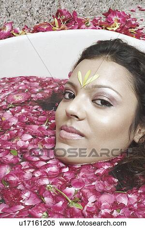 Stock Photography - Portrait of a young woman lying in a bathtub. Fotosearch