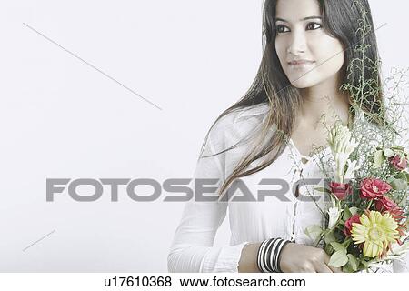Young woman holding a bouquet of flowers View Large Photo Image Stock Photo - Young woman holding a bouquet of flowers. Fotosearch