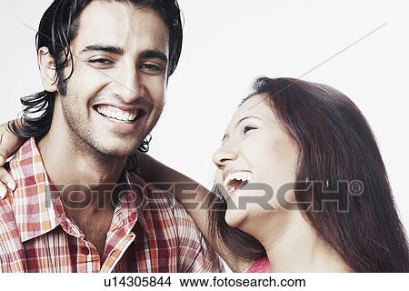 Close-up of a young couple smiling View Large Photo Image Picture - Close-up of a young couple smiling. Fotosearch