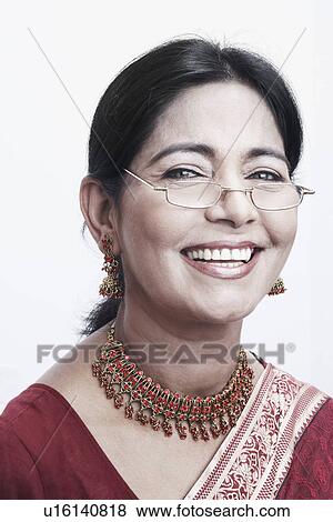 Stock Photo - Portrait of a mature woman peeking over her eyeglasses smiling. Fotosearch
