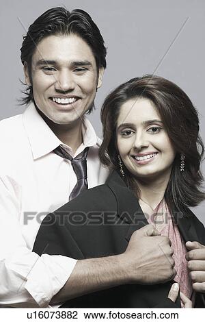 Stock Image - Portrait of a young couple smiling. Fotosearch