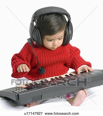 Close-up of a baby boy wearing headphones playing an electronic piano View Large Photo Image Stock Photo - Close-up of a baby boy wearing headphones playing an electronic piano. Fotosearch