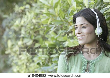 Close-up of a young woman wearing headphones View Large Photo Image Stock Image - Close-up of a young woman wearing headphones. Fotosearch