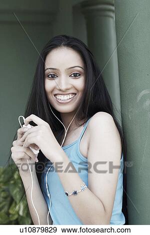 Stock Photo - Portrait of a teenage girl listening to an MP3 player. Fotosearch