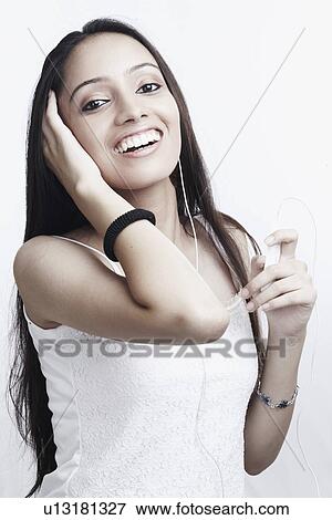Stock Photo - Portrait of a teenage girl listening to an MP3 player. Fotosearch