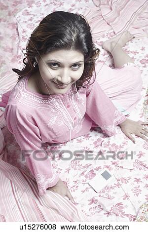 Stock Photo - Portrait of a young woman sitting on fabric. Fotosearch