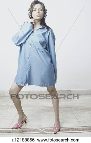 Stock Photograph - Portrait of a young woman wearing headphones listening to music. Fotosearch