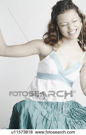 Young woman listening to music wearing headphones View Large Photo Image Stock Photo - Young woman listening to music wearing headphones. Fotosearch