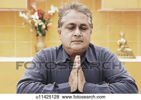 Stock Photo - Close-up of a mature man in a prayer position. Fotosearch
