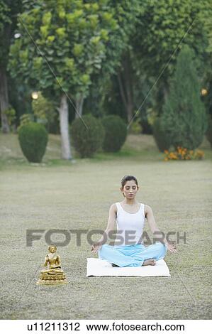 Stock Image - High angle view of a young woman meditating. Fotosearch