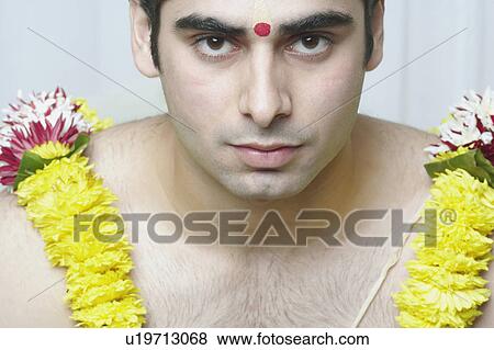 Stock Photo - Portrait of a young man wearing a garland. Fotosearch