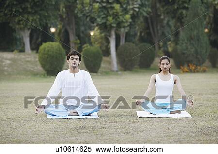 Young couple doing yoga in the garden View Large Photo Image Stock Photography - Young couple doing yoga in the garden. Fotosearch