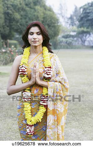 Stock Photo - Young woman standing in a prayer position with her eyes closed. Fotosearch
