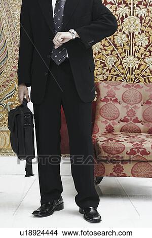 Picture - Businessman looking at his wristwatch. Fotosearch