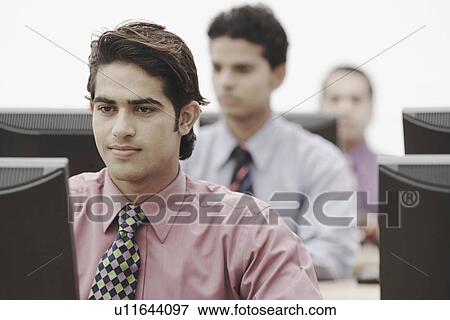 Businessmen working on computers in an office View Large Photo Image Stock Photo - Businessmen working on computers in an office. Fotosearch
