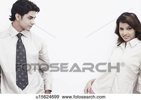 Stock Photo - Close-up of a businessman looking at a businesswoman smiling. Fotosearch