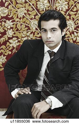 Stock Photograph - Close-up of a businessman sitting on a chair. Fotosearch