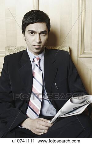 Portrait of a businessman holding a newspaper View Large Photo Image Stock Image - Portrait of a businessman holding a newspaper. Fotosearch