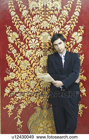 Portrait of a businessman holding a newspaper View Large Photo Image Stock Photo - Portrait of a businessman holding a newspaper. Fotosearch