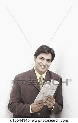Stock Photography - Portrait of a businessman holding a newspaper. Fotosearch