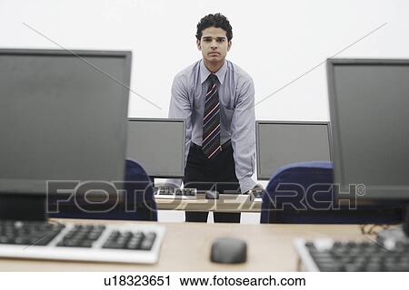 Stock Image - Portrait of a businessman leaning on the table. Fotosearch