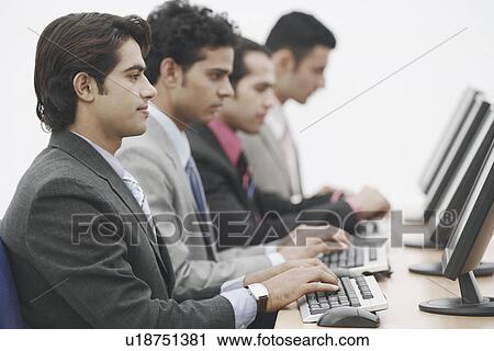 Side profile of four businessmen sitting in front of computers View Large Photo Image Stock Image - Side profile of four businessmen sitting in front of computers. Fotosearch