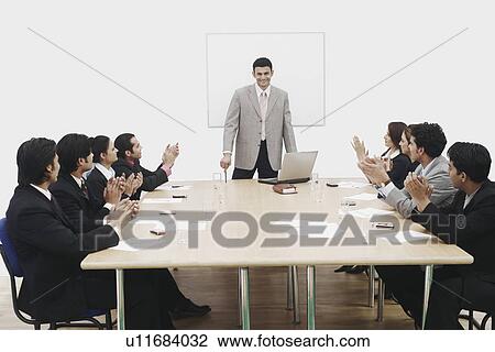 Stock Image - Group of business executives applauding at a presentation. Fotosearch