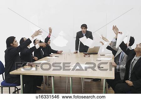 Group of business executives throwing sheets of paper in a meeting View Large Photo Image Stock Photograph - Group of business executives throwing sheets of paper in a meeting. Fotosearch