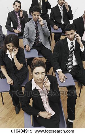 Stock Photography - High angle view of business executives talking on mobile phones. Fotosearch