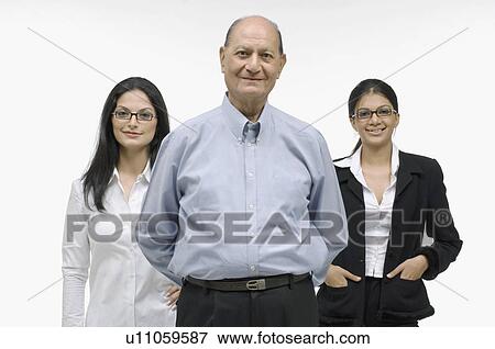 Portrait of a businessman with two businesswomen standing behind him View Large Photo Image Stock Photo - Portrait of a businessman with two businesswomen standing behind him. Fotosearch