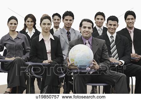 Stock Photo - Portrait of a group of business executives sitting in a meeting. Fotosearch