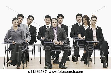 Stock Photo - Portrait of business executives sitting on chairs. Fotosearch