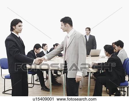Side profile of two businessmen shaking hands in a meeting View Large Photo Image Stock Image - Side profile of two businessmen shaking hands in a meeting. Fotosearch