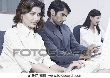 Stock Photo - Two businesswomen and a businessman in an office. Fotosearch