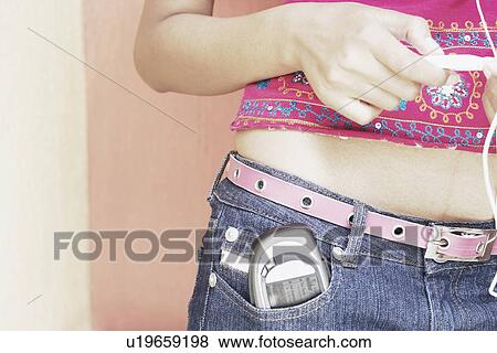 Mid section view of a woman with a mobile phone in her pocket View Large Photo Image Stock Photo - Mid section view of a woman with a mobile phone in her pocket. Fotosearch