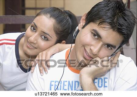 Stock Photography - Portrait of a young couple listening to music. Fotosearch