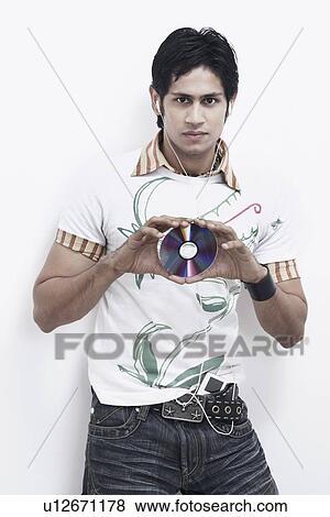 Portrait of a young man holding a CD and listening to music View Large Photo Image Stock Photo - Portrait of a young man holding a CD and listening to music. Fotosearch
