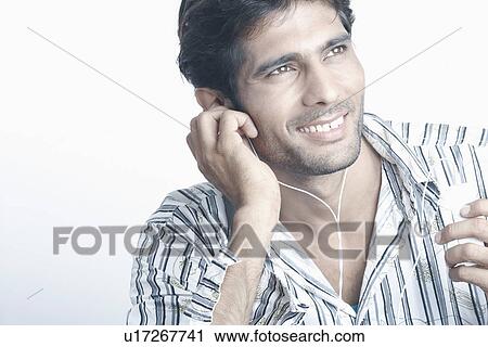 Stock Image - Young man listening to an MP3 Player. Fotosearch