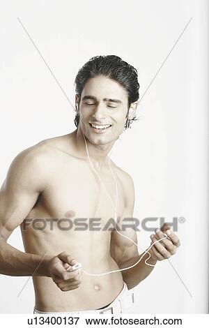 Young man listening to music wearing headphones View Large Photo Image Stock Photo - Young man listening to music wearing headphones. Fotosearch