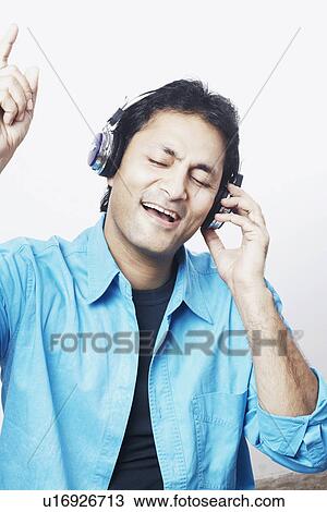 Young man listening to music with his eyes closed View Large Photo Image Stock Image - Young man listening to music with his eyes closed. Fotosearch