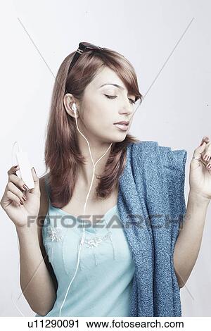 Young woman listening to an MP3 player View Large Photo Image Stock Image - Young woman listening to an MP3 player. Fotosearch