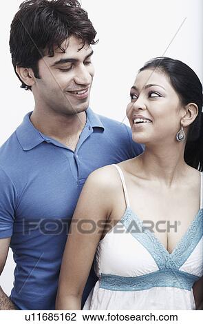 Close-up of a young couple looking at each other View Large Photo Image Stock Image - Close-up of a young couple looking at each other. Fotosearch